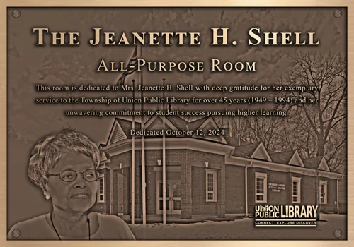 Bronze Jeanette H. Shell All-Purpose Room dedication plaque with an engraved portrait and a library building background.