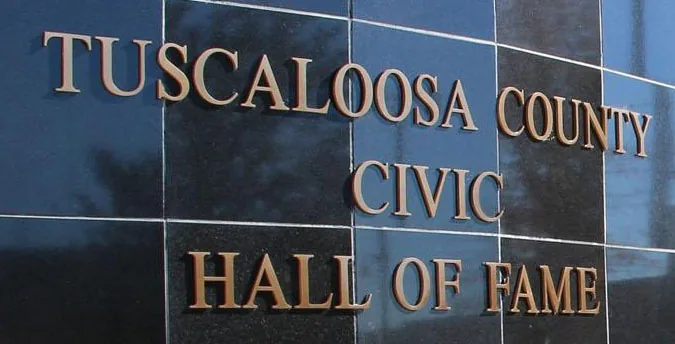 Custom cast bronze metal letters mounted on a building wall.