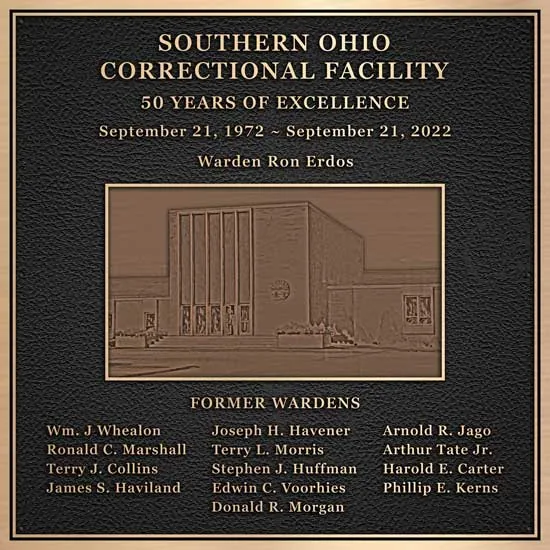 A government building dedication plaque with a photo of the new building.