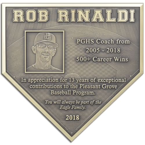 A bronze plaque in the shape of a home plate used to recognize the career wings of a baseball coach.