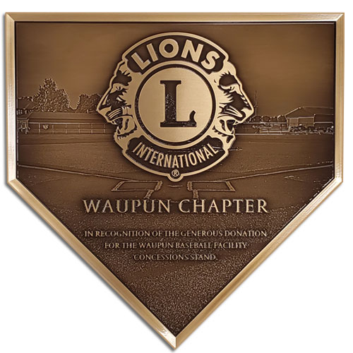A bronze plaque in the shape of a home plate to recognizing a baseball field sponsor.